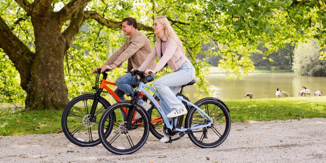 Two riders on NINE09 electric bikes in a park, riding within Europe's 25 km/h eBike speed limit